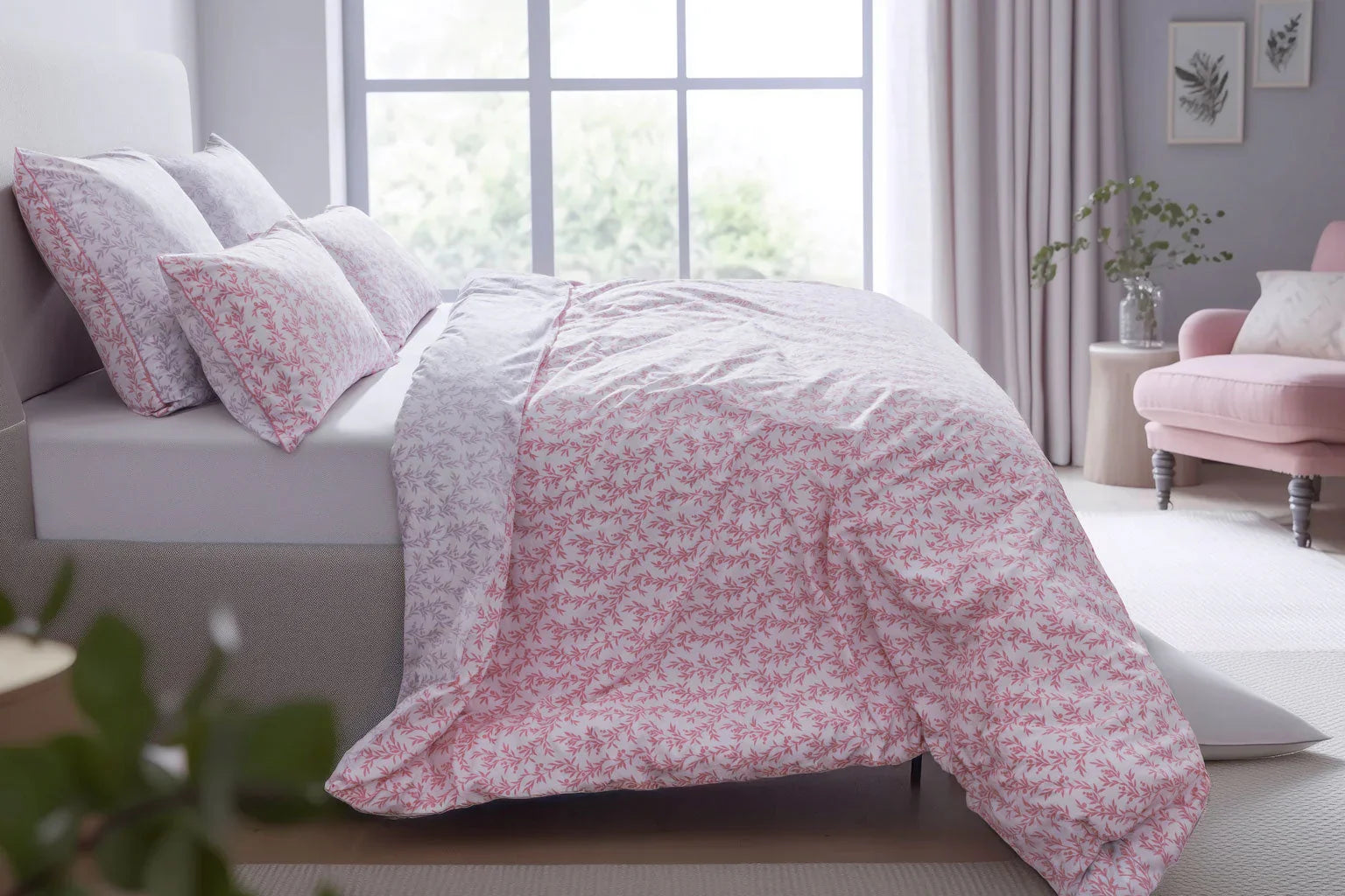 Bed with pink floral bedding in a bright bedroom