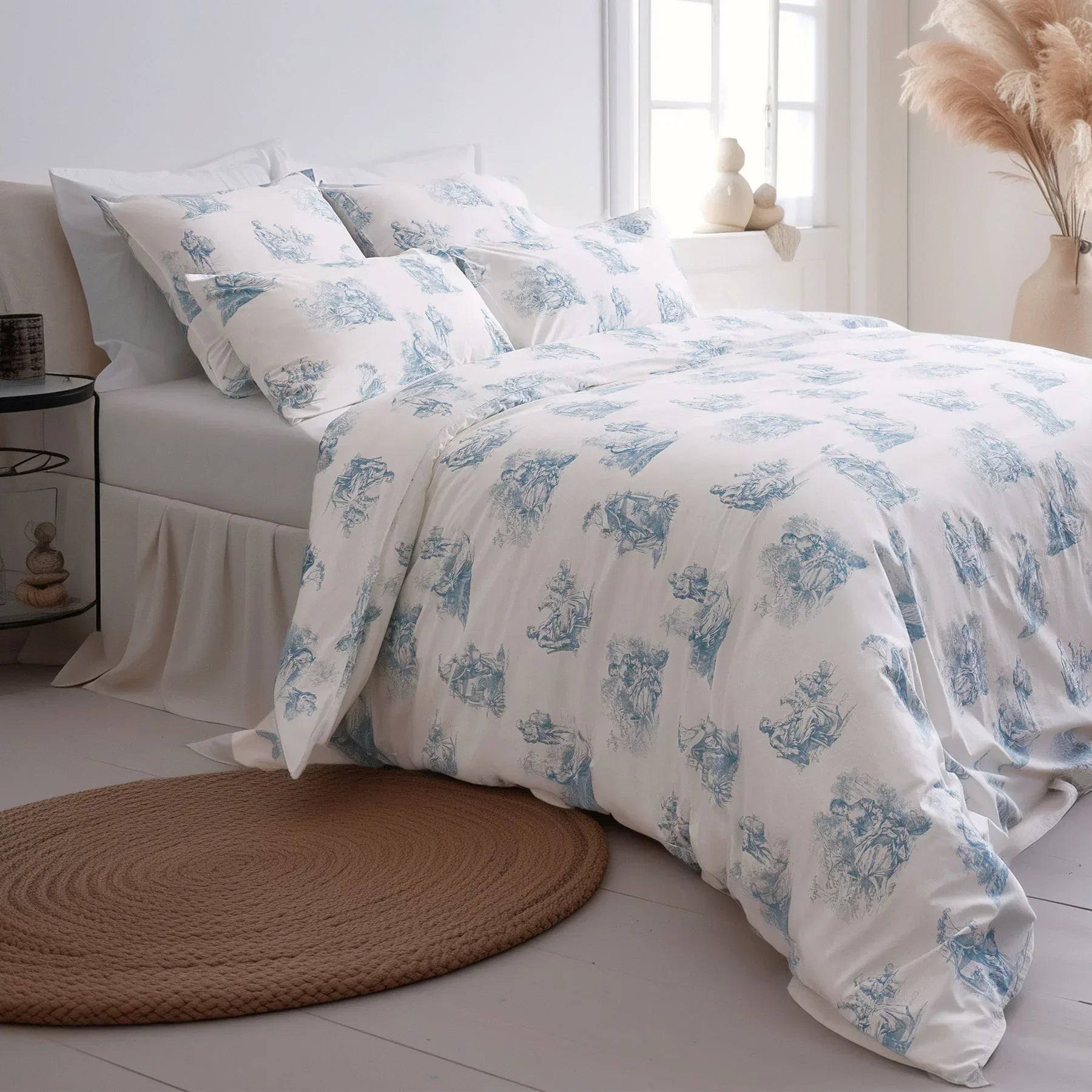 Blue and white toile de Jouy duvet cover set on a bed in a bright, modern bedroom