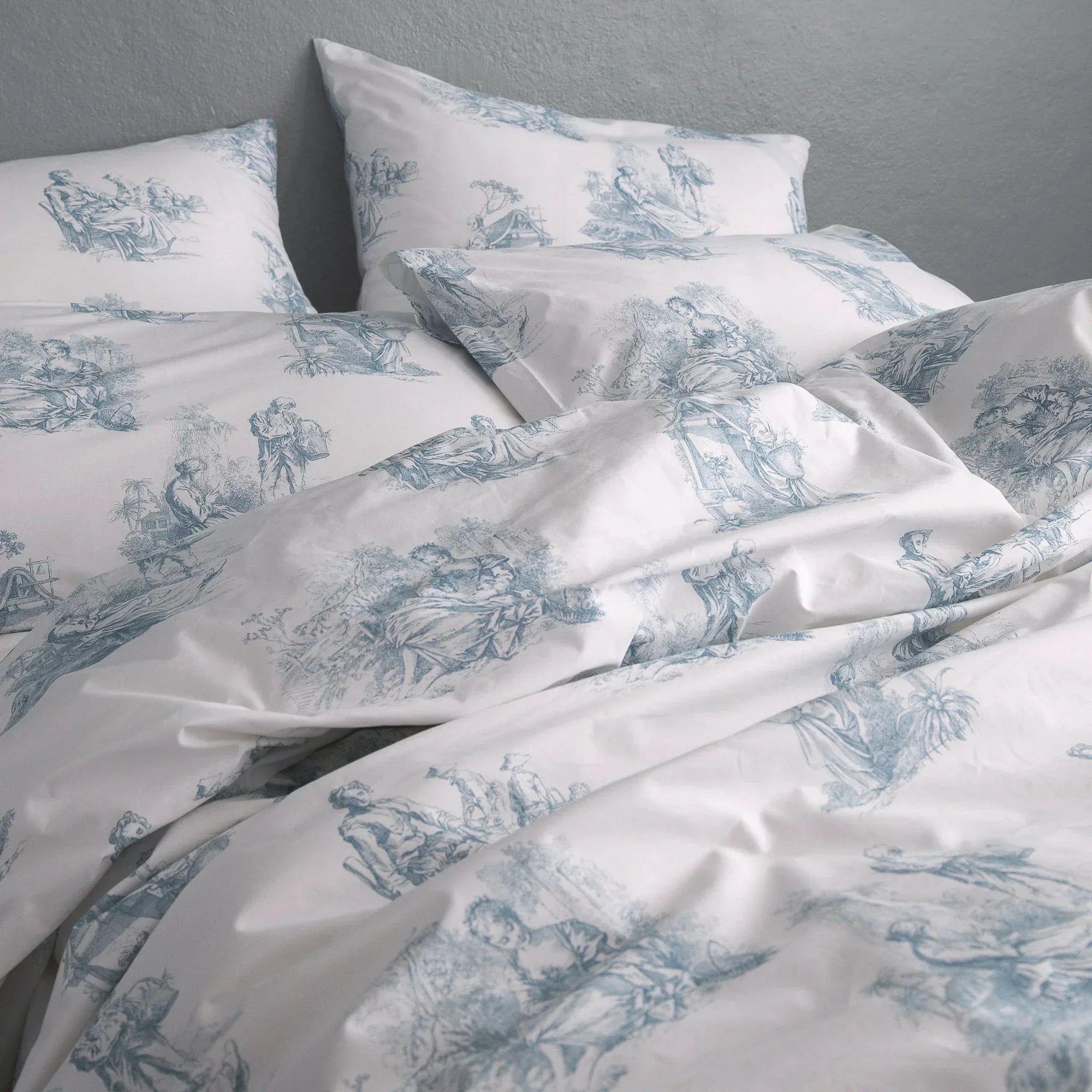 Blue and white toile de Jouy duvet cover set with vintage scenic pattern on bed